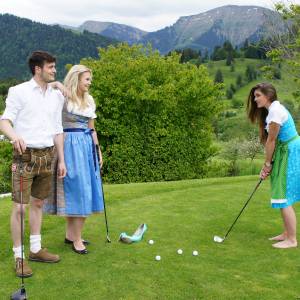 Personen in Tracht spielen Golf