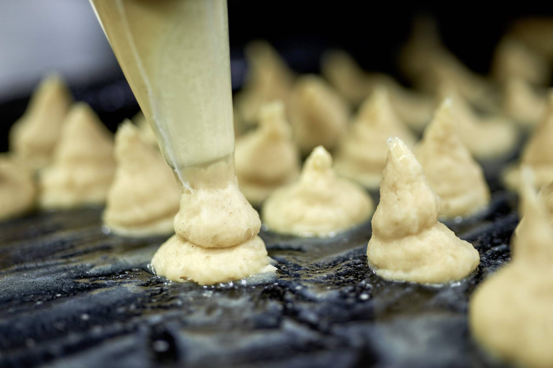 Koch beim Gebäckspritzen