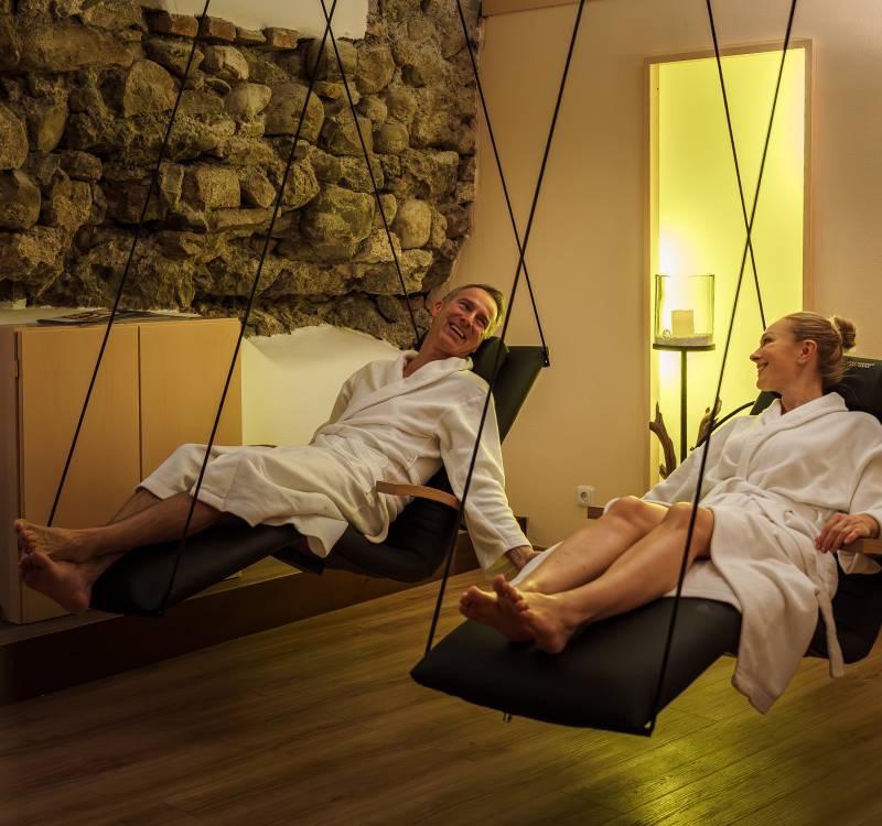 Paar in den Schwebeliegen im Wellness-Ruheraum