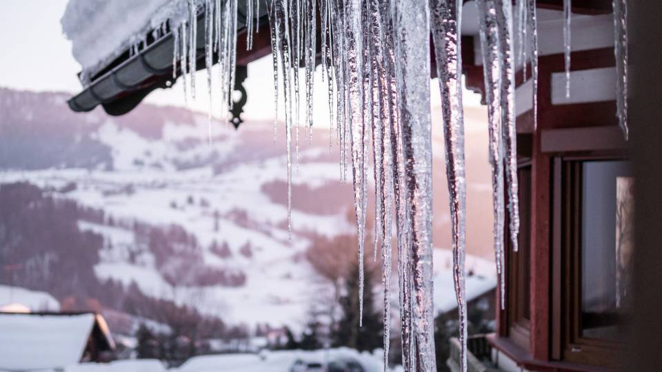 Eiszapfen hängen von Dach